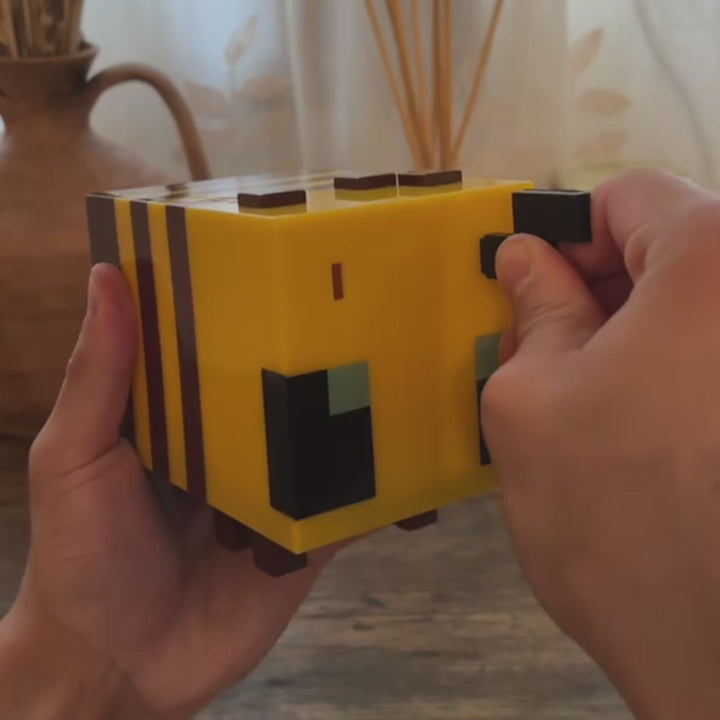 lampe abeille Minecraft lumineuse LED. Présentation réaliste de l’objet déco pixelisé à collectionner, cadeau idéal pour enfants fans du jeu.